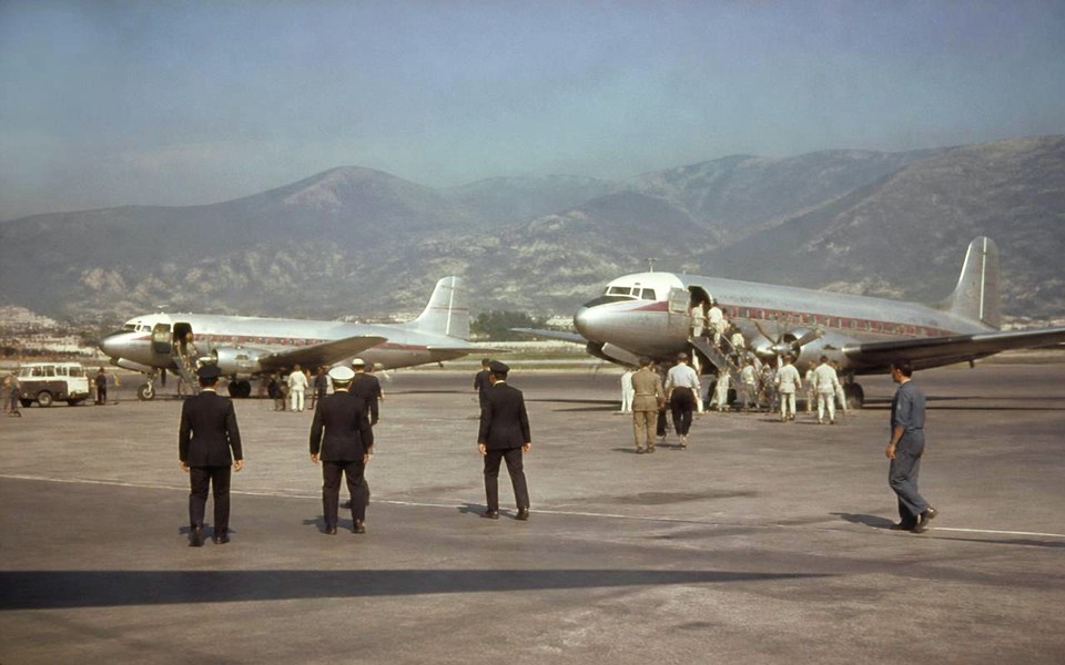 1957, Beirut International Airport, Lebanon: Two Douglas DC-3 propeller airliners of Cross Atlantic Airways parked tail-down on an airport apron in 1957, with flight crew and ground handlers loading baggage by hand. — Avanti Holding, Cross Atlantic Airways.