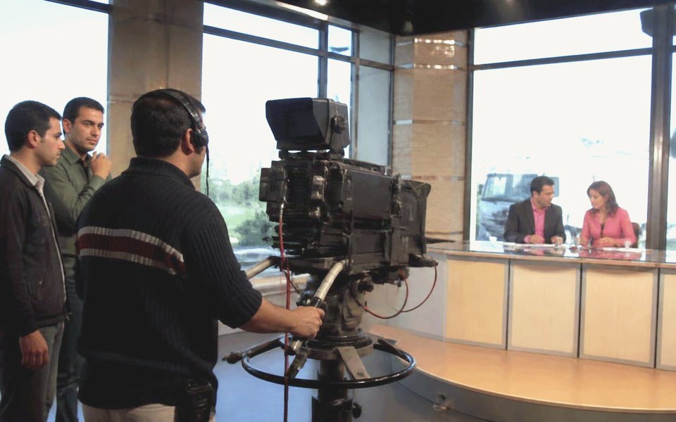 2006, Regional broadcast studios, serving the Arab world: Presenters and crew working in a three-camera satellite broadcast studio, with lighting rigs, autocue and gallery monitors visible. — Avanti Holding, ABCD Arabia.